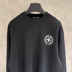 Black long-sleeve crewneck sweatshirt with small circular chest logo