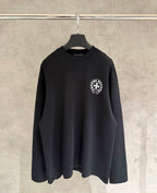 Black long-sleeve crewneck sweatshirt with small circular chest logo patch