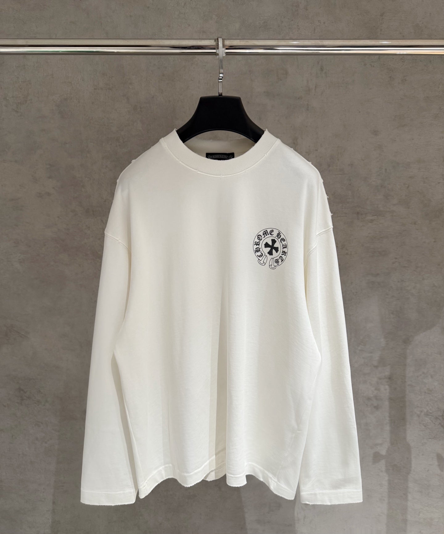 White long-sleeve shirt on hanger, small chest emblem print
