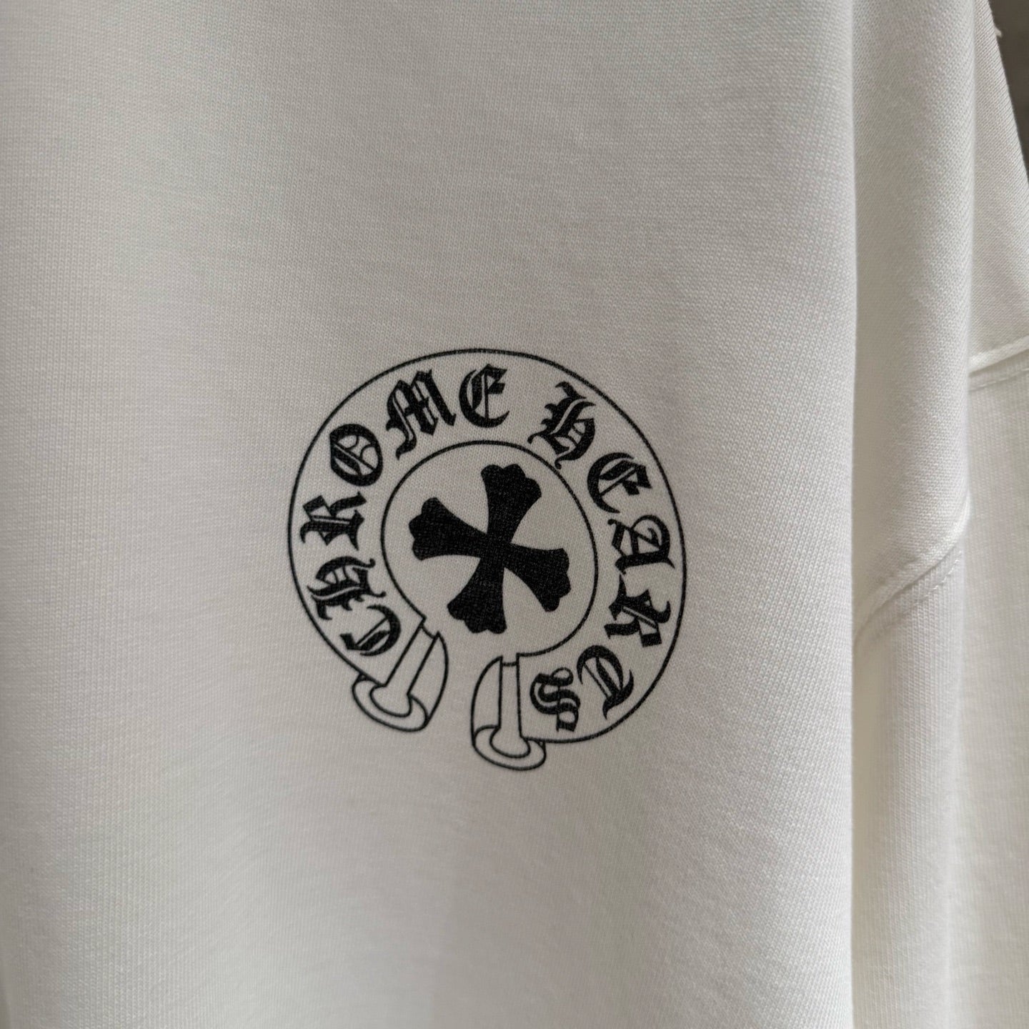White long-sleeve shirt, close-up of circular chest emblem patch