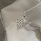White long-sleeve shirt sleeve with care label tag at neckline