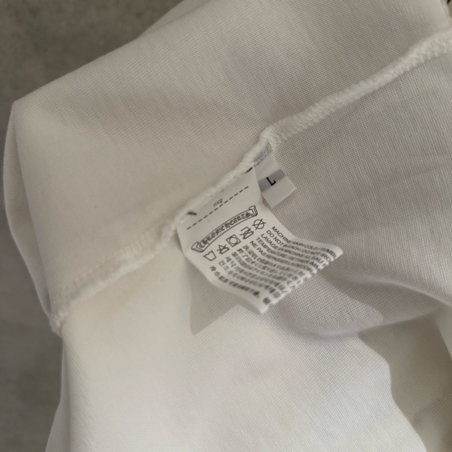 White long-sleeve shirt sleeve with care label tag at neckline
