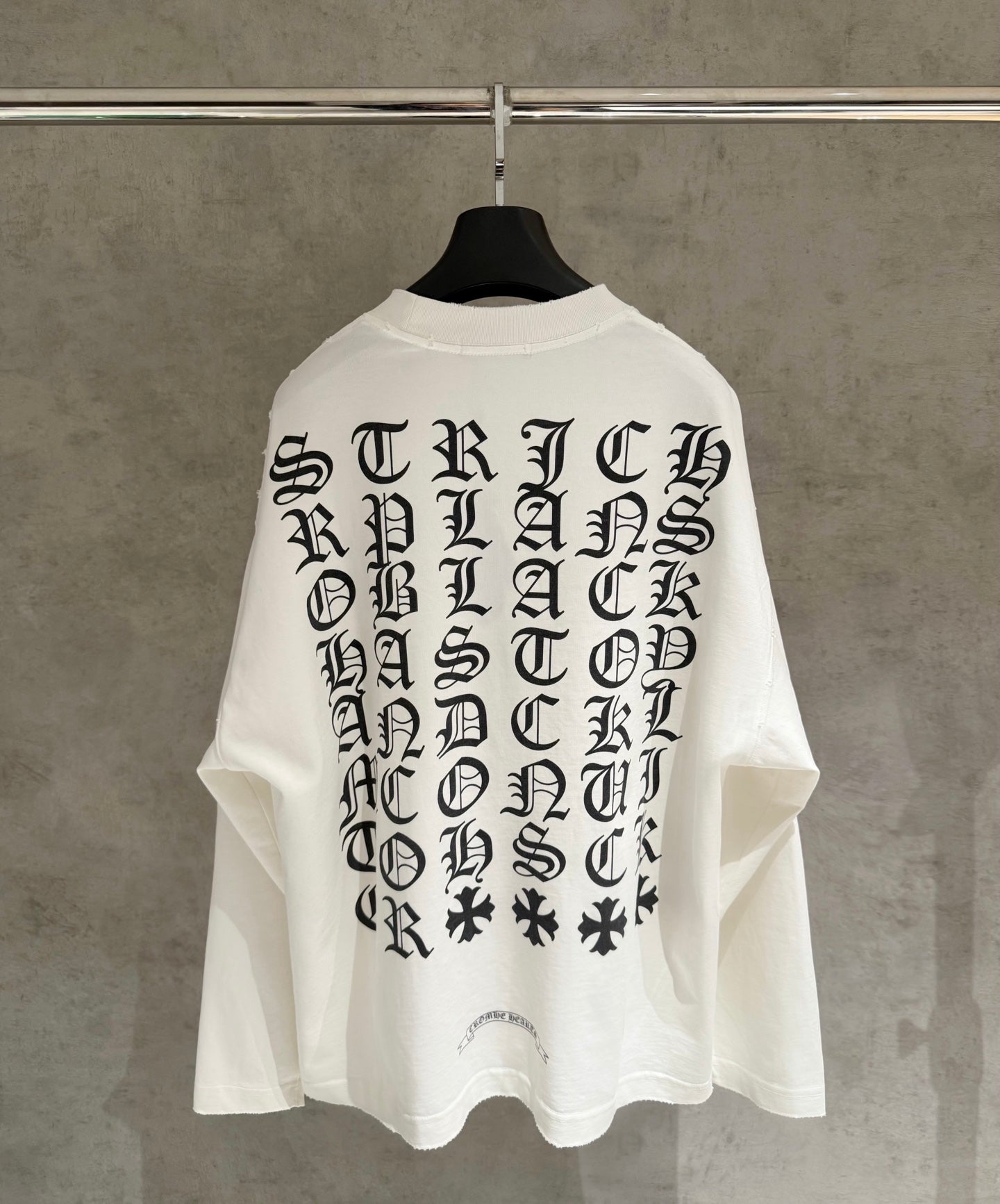 White long-sleeve shirt on hanger, large back gothic letter print
