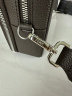Fendi bag strap clasp with silver hardware and zipper pull on dark textured leather.