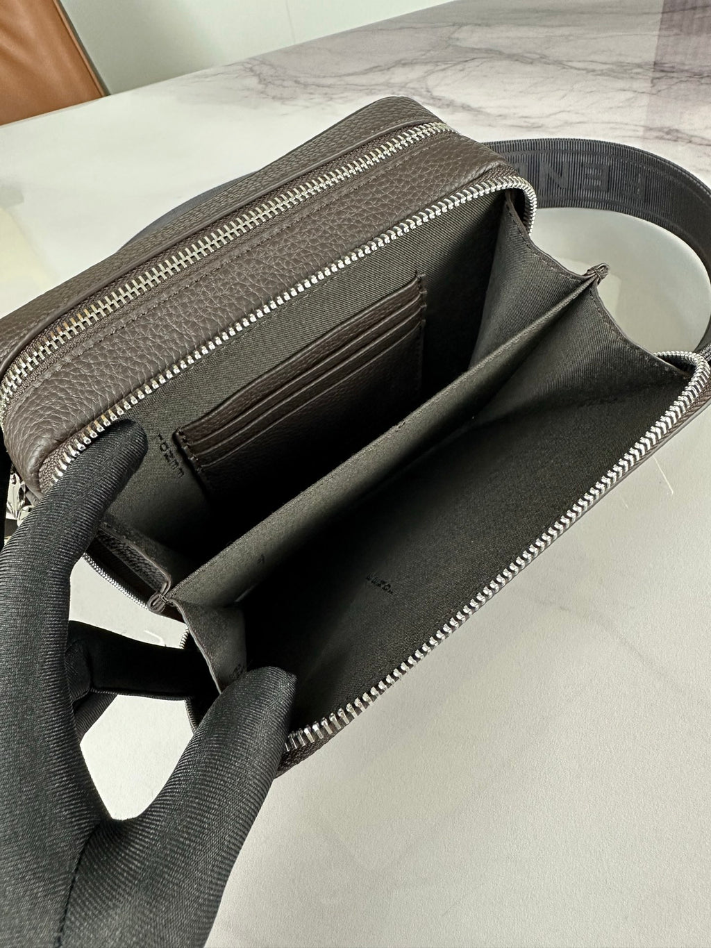 Fendi crossbody bag open interior with dark lining and silver zipper along the top edge.