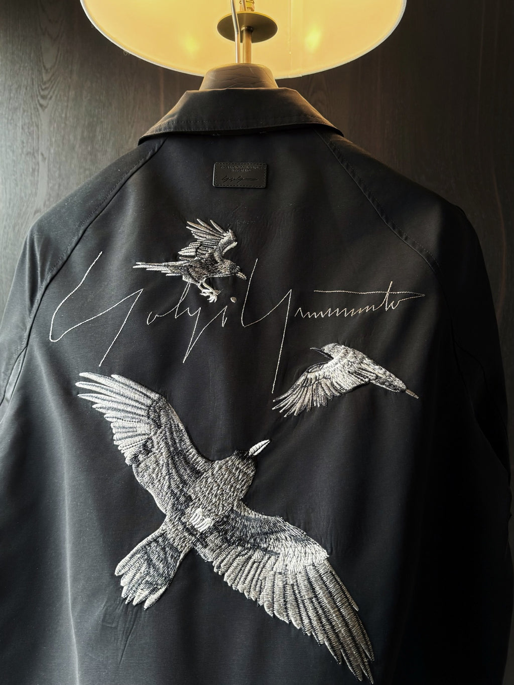 Amiri dark button-up shirt back yoke with white bird embroidery and script