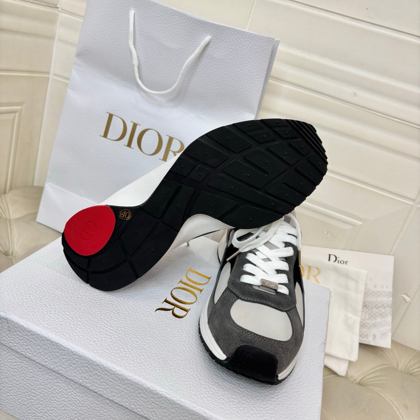 Unisex sneakers outsole view, black tread with gray/white uppers and red heel