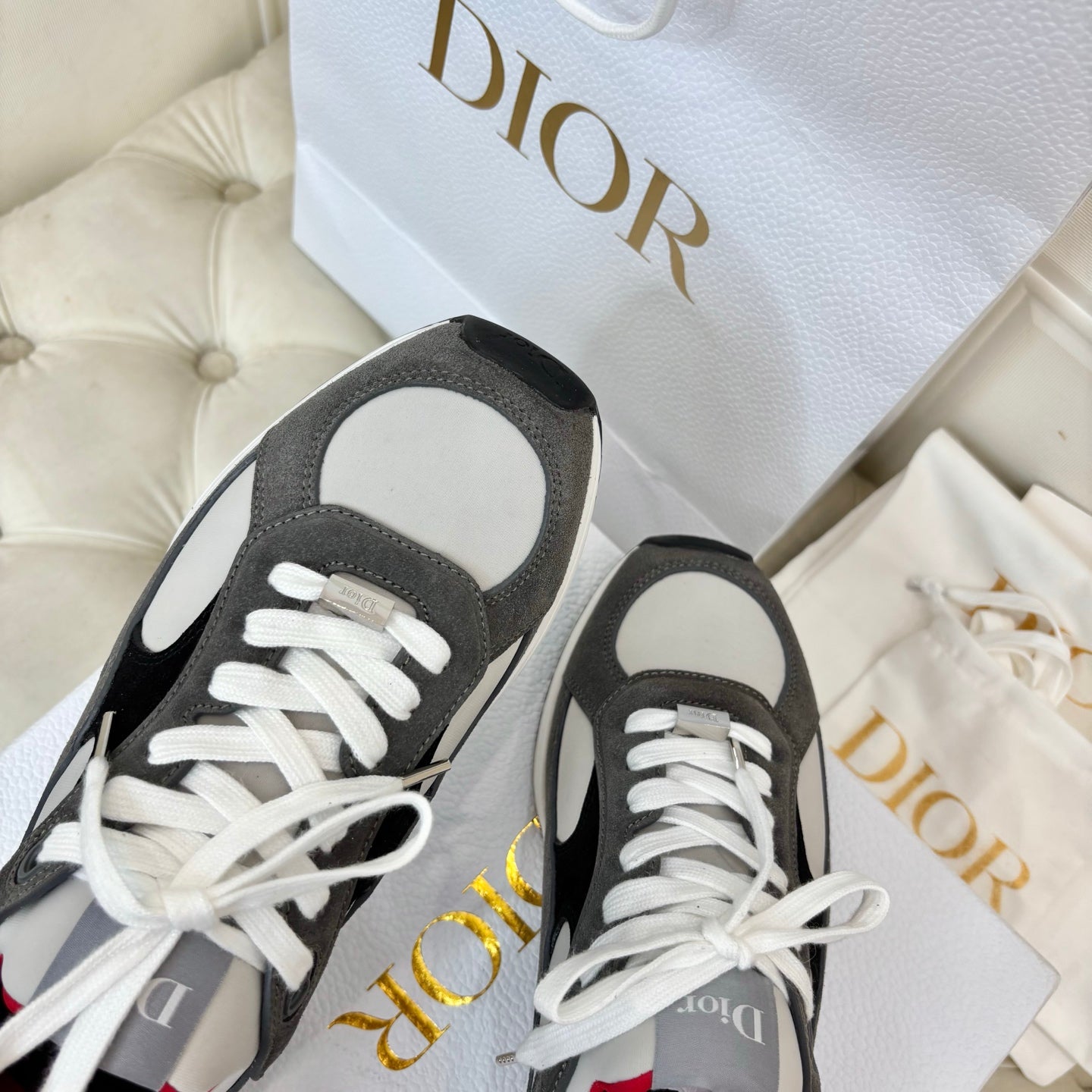Unisex sneaker close-up, gray suede with black panels, white laces and white toe