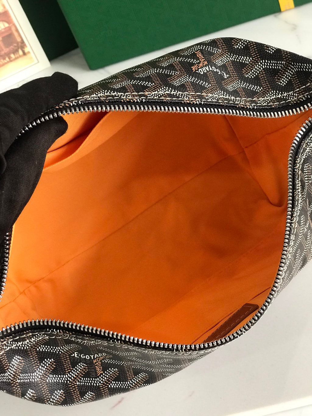 Monogram bag interior with orange lining and silver-tone zipper edge