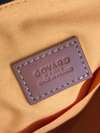 Leather brand patch tag with embossed text on tan fabric flap