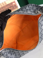Goyard bag open top with orange fabric lining and zippered opening on monogram canvas