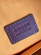 Leather brand label on beige lining inside handbag, embossed text