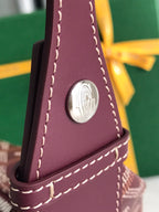 Leather front panel with round emblem and stitched trim on patterned bag