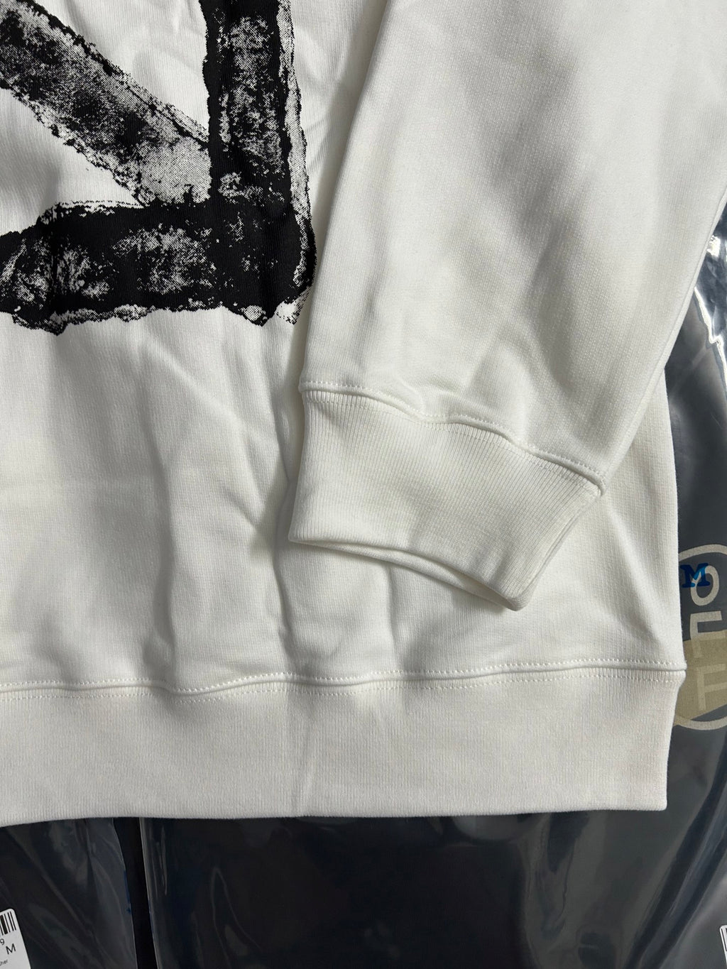 Off-white sweatshirt sleeve and front hem with kangaroo pocket seam