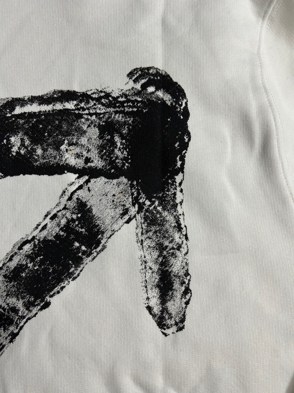 White hoodie close-up of black arrow-like X graphic print