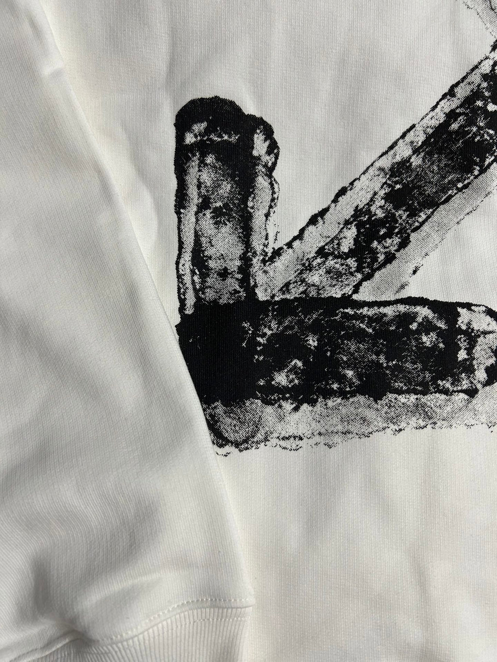 White hoodie close-up of black X graphic print