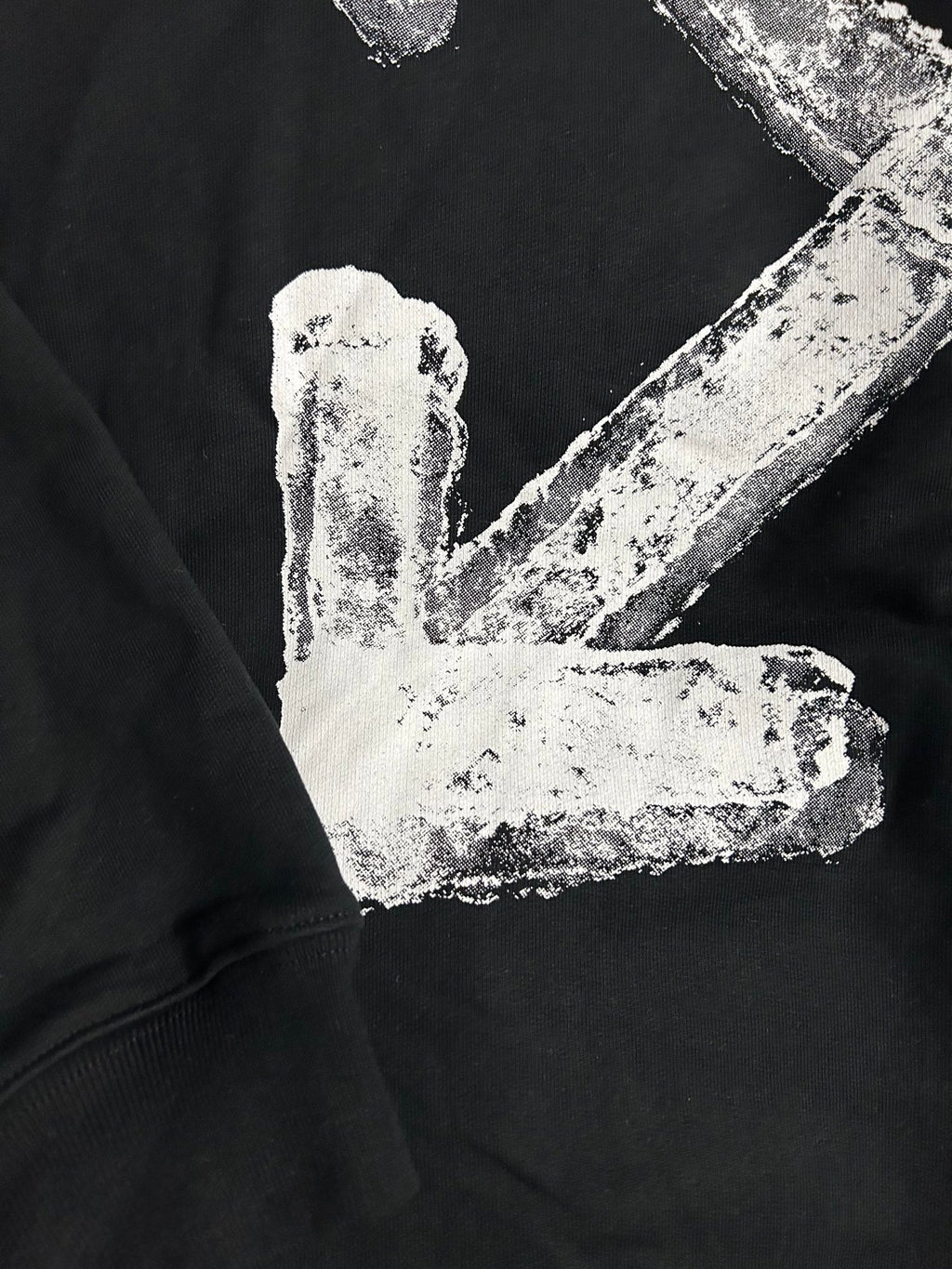 Black hoodie with distressed white arrow logo and block lettering