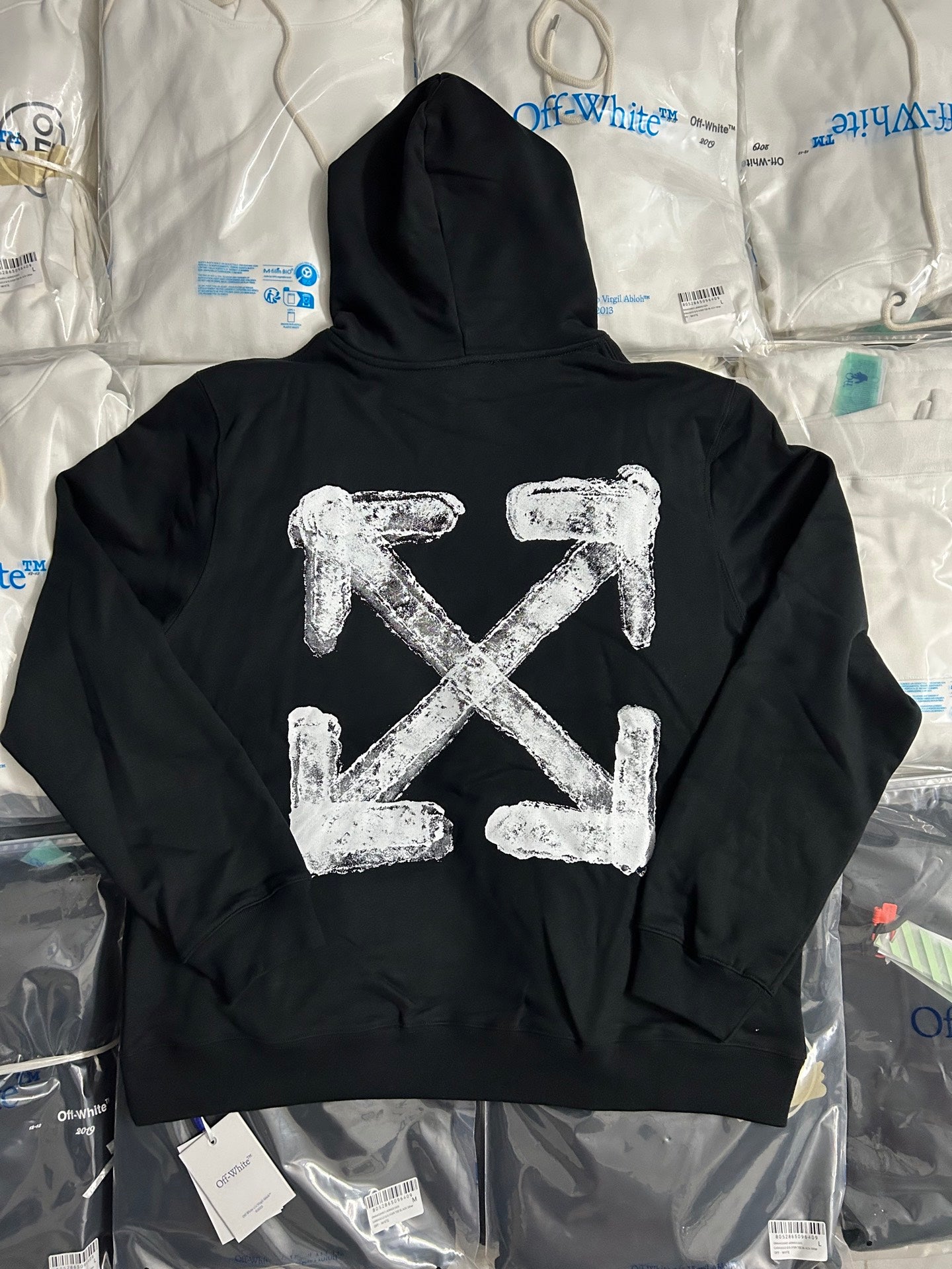 Black pullover hoodie with large white arrow logo on back