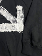 Black hoodie with distressed white arrow logo detail and ribbed sleeve cuff