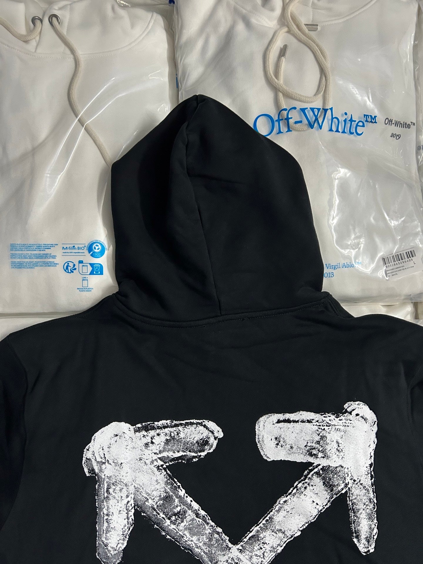 Black hoodie with large white arrow logo and hooded neckline