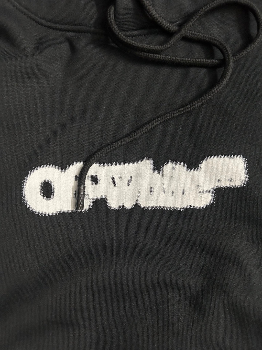 Black hoodie with white distressed logo print and drawstring cords