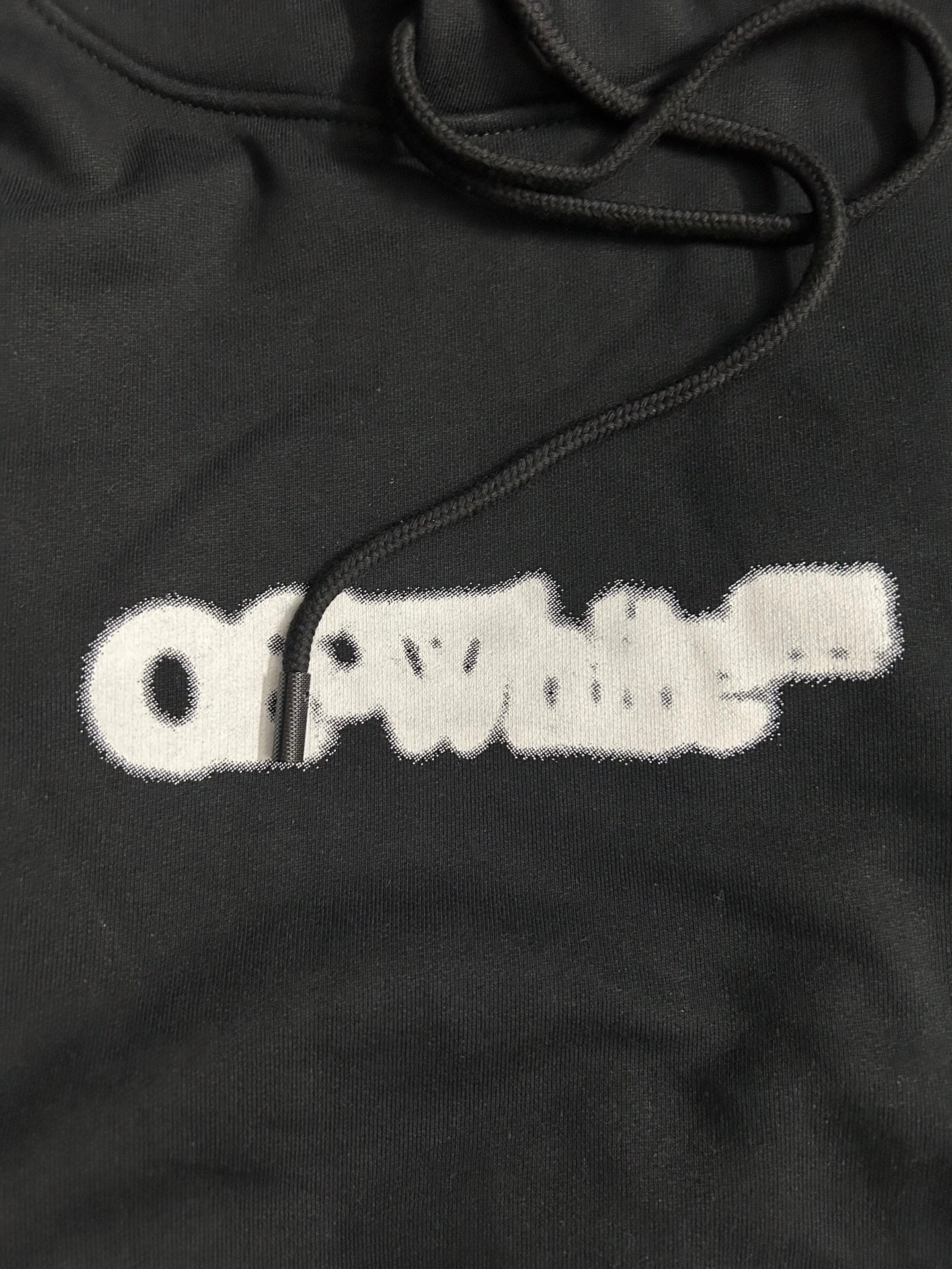 Black hoodie with white distressed logo print and drawstring cords