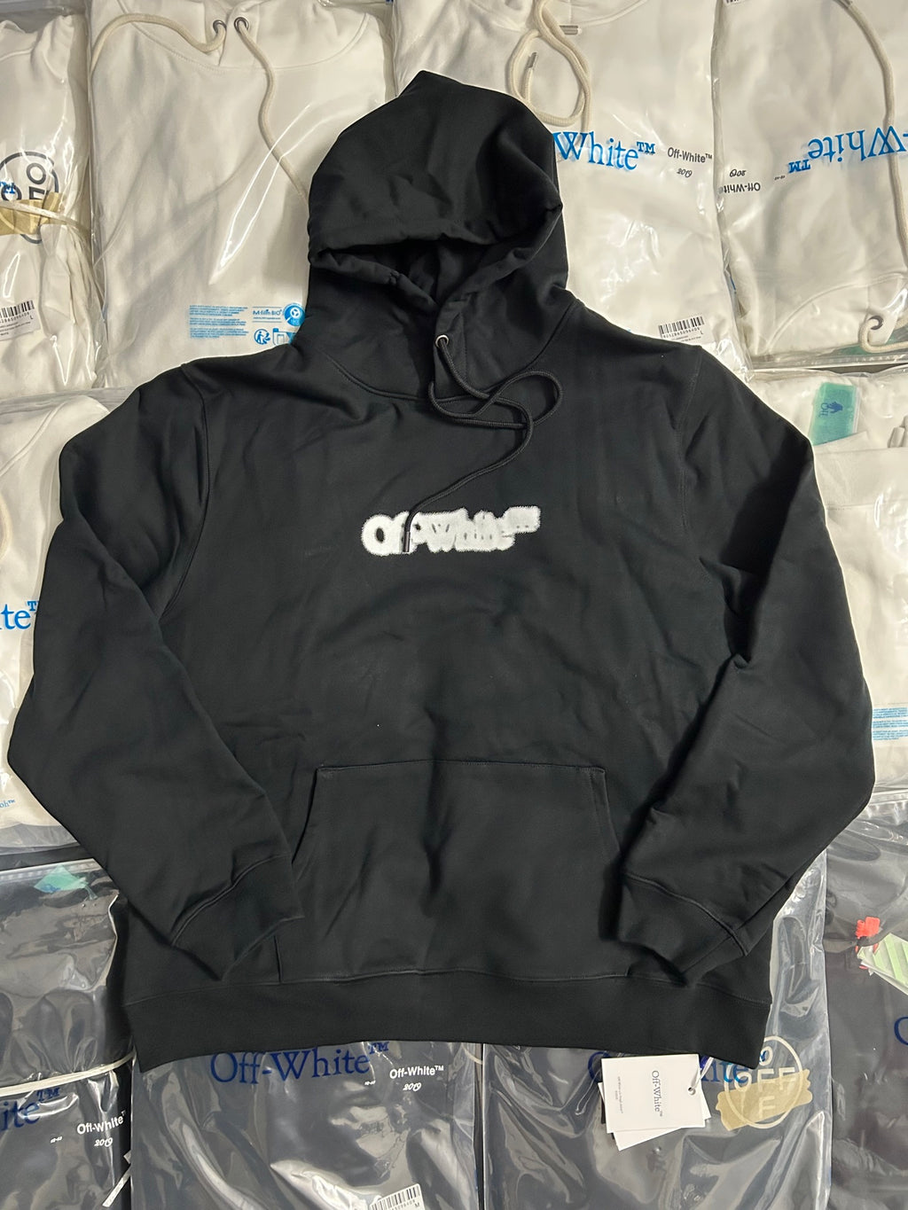 Black pullover hoodie with front pocket, hood strings, and small chest logo