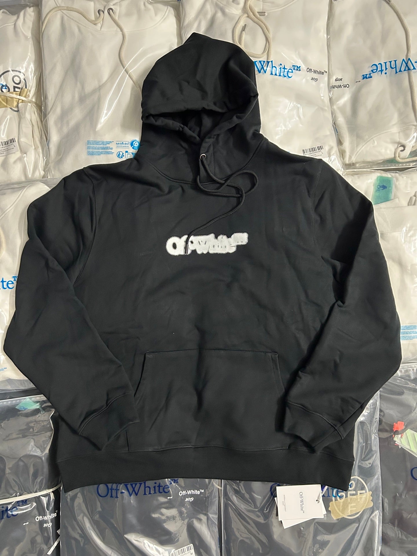 Black pullover hoodie with front pocket, hood strings, and small chest logo
