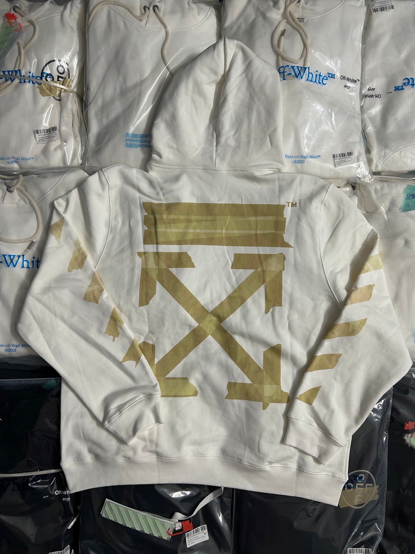 Off-White hooded sweatshirt front view with large gold arrow-style emblem