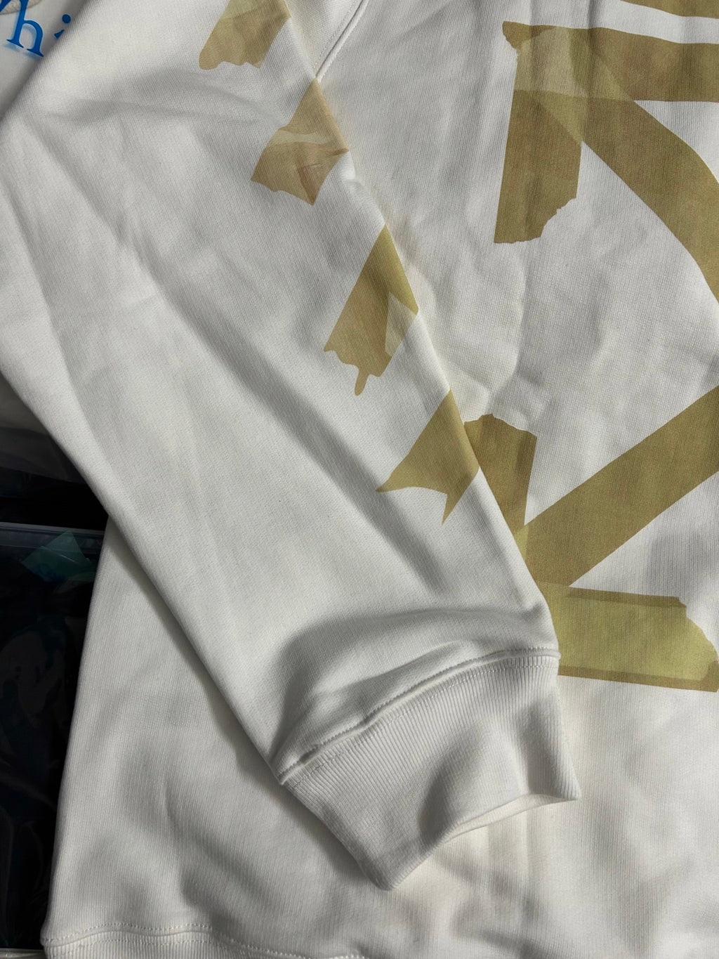 Off-White hooded sweatshirt sleeve and cuff with gold geometric print