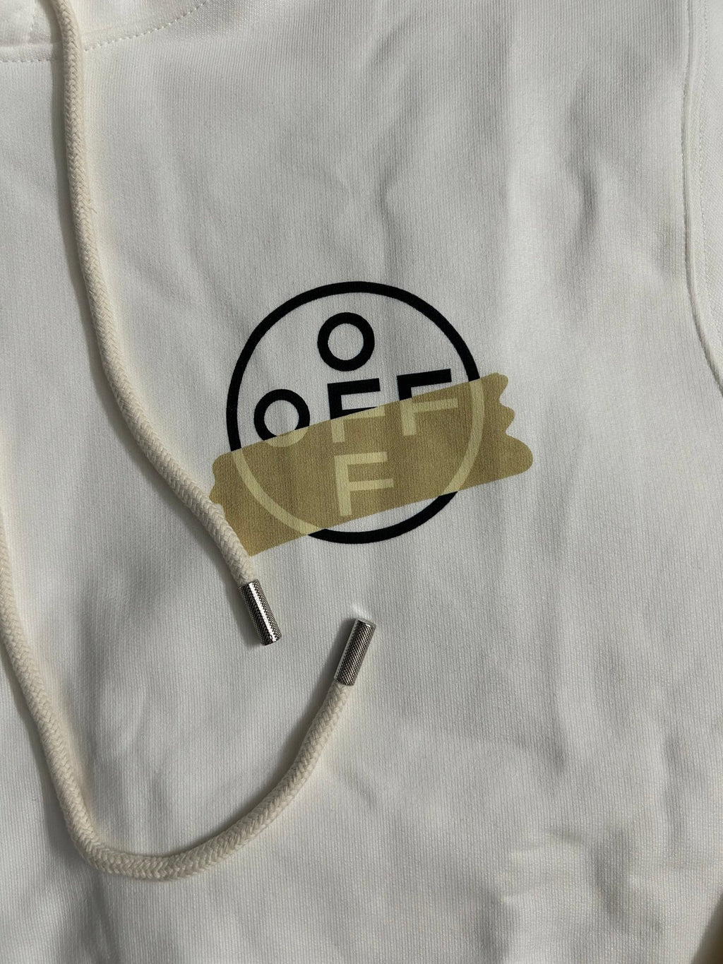Off-White hooded sweatshirt neckline closeup with black O/F logo and metal aglets