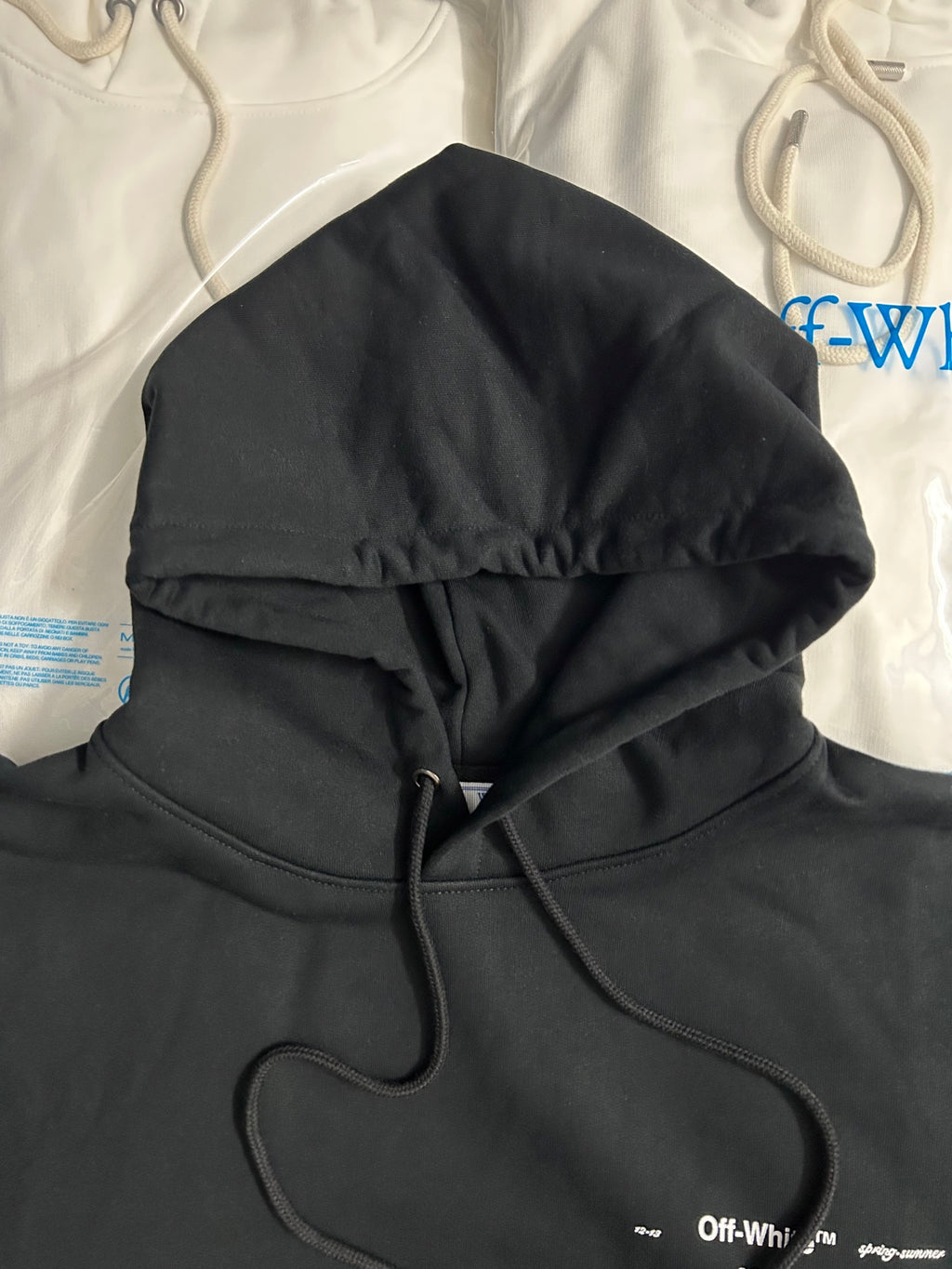 Black hoodie close view with hood, drawstrings, and front kangaroo pocket