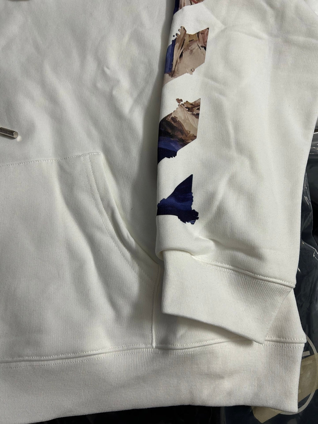Off-White white hoodie sleeve with blue graphic print and ribbed cuff