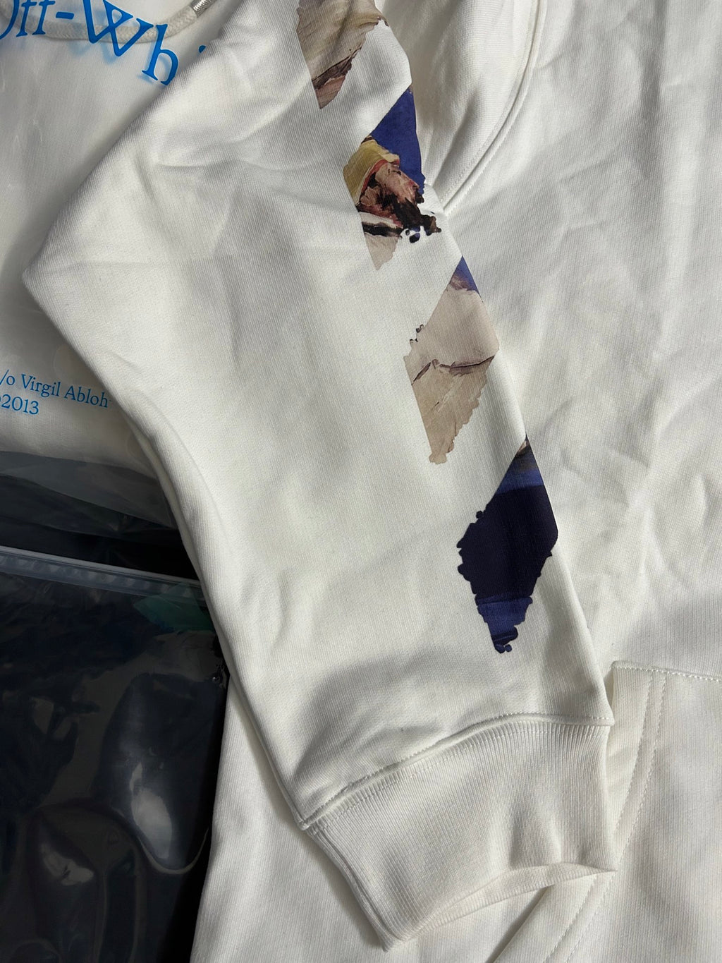 Off-White white hoodie front with blue abstract print and kangaroo pocket seam