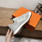 Light gray leather sneaker with white laces, padded collar, cushioned sole