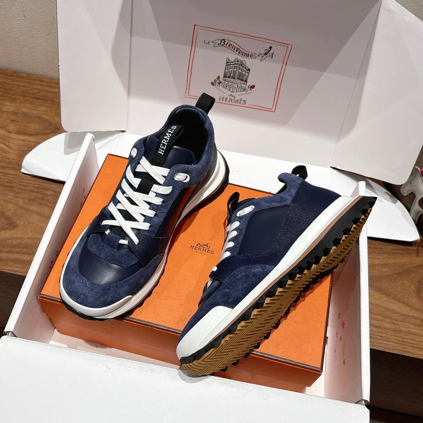 Unisex dark blue sneakers with white laces, one sole showing textured tread pattern
