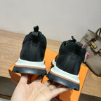Hermes unisex sneakers in black, visible heel with blue sole trim and white platform