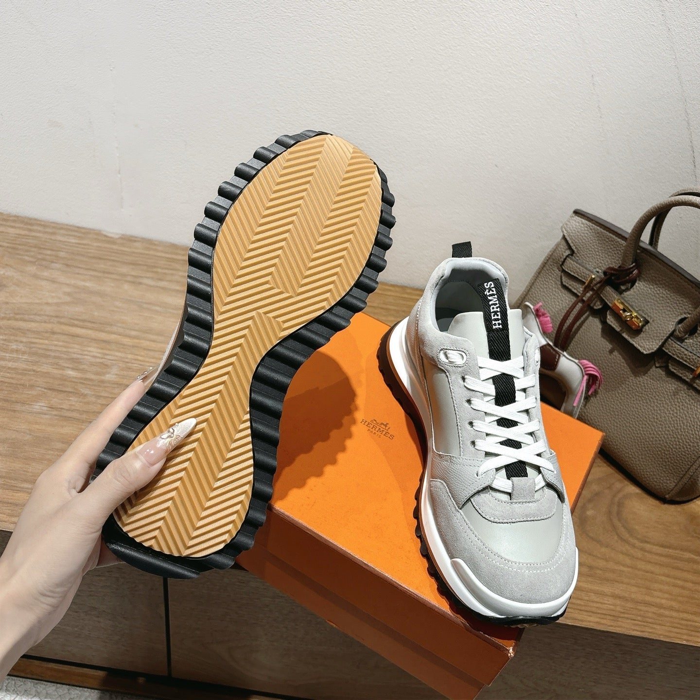 Sneaker outsole of light gray leather sneakers, textured rubber tread with black trim