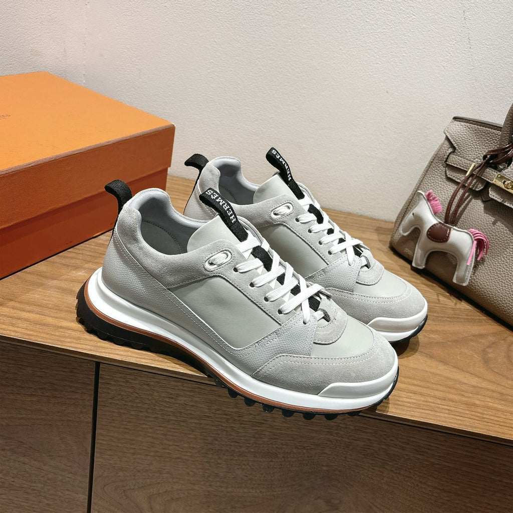 Pair of Hermes unisex sneakers, light gray with black heel tabs, white laces, thick sole.