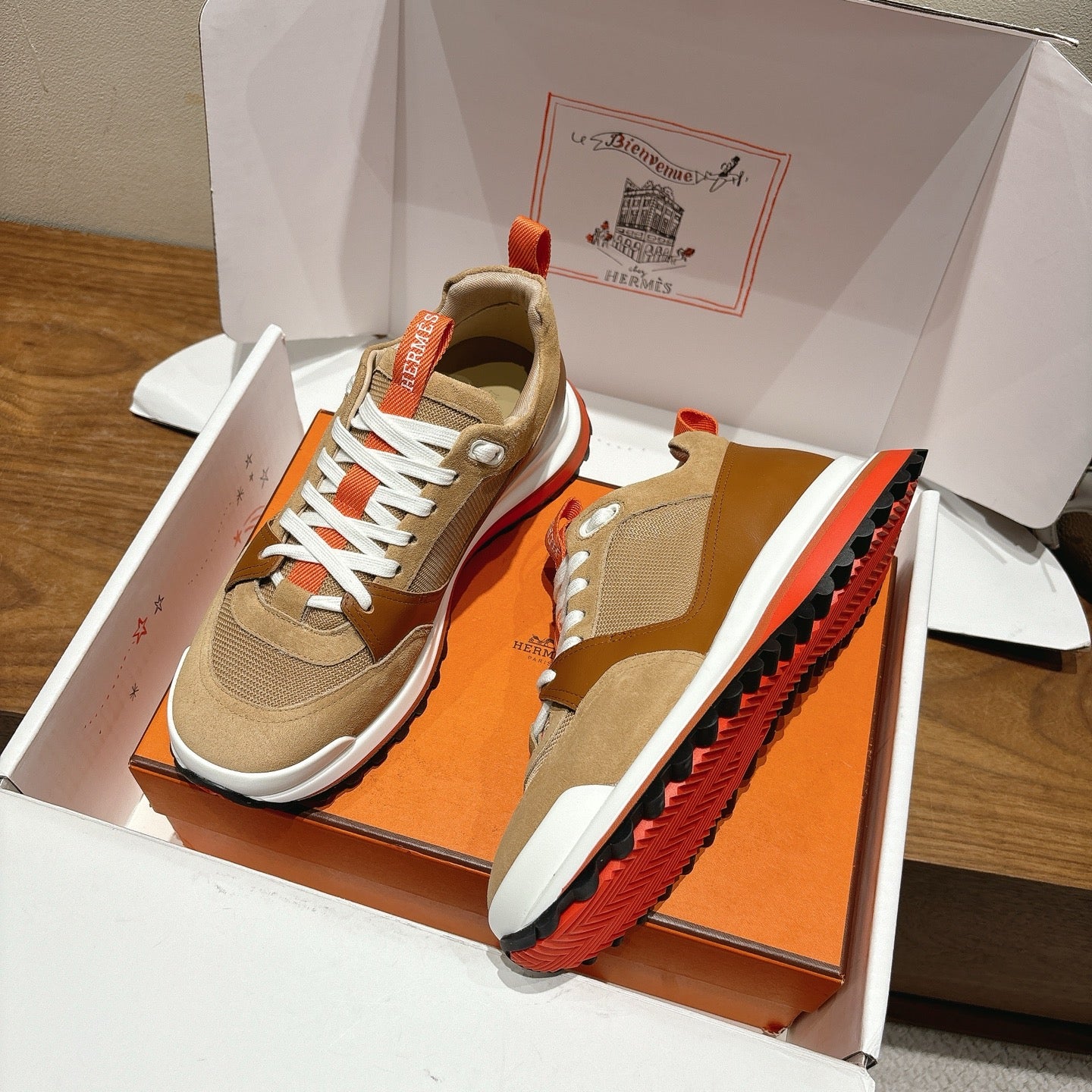 Hermes unisex sneakers in box with side profile, beige uppers and red-orange sole details