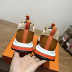 Hermes unisex sneakers back view with orange heel straps and white cushioned soles