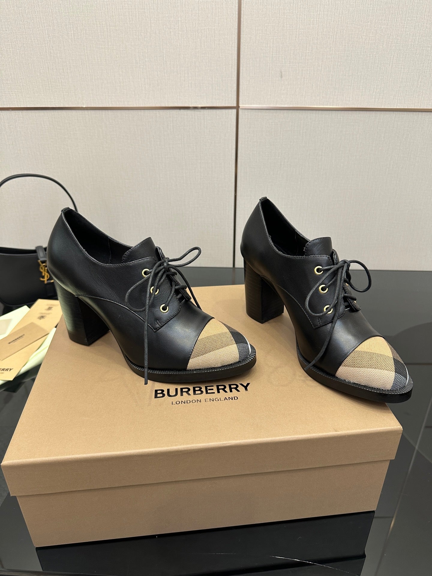 Black lace-up ankle boots with beige check toe panels and Burberry branding