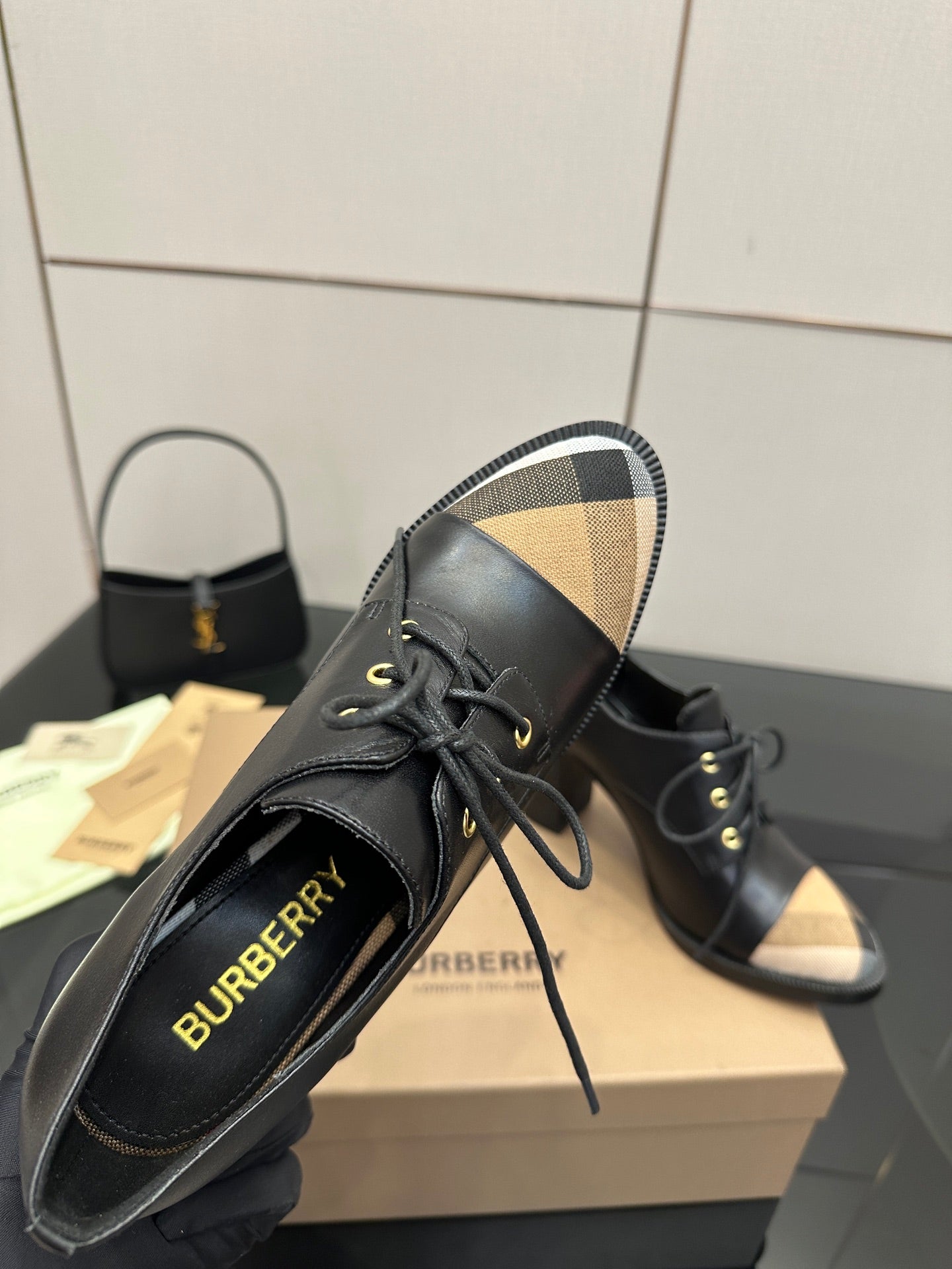 Black lace-up ankle boots with beige check panels and Burberry logo on uppers