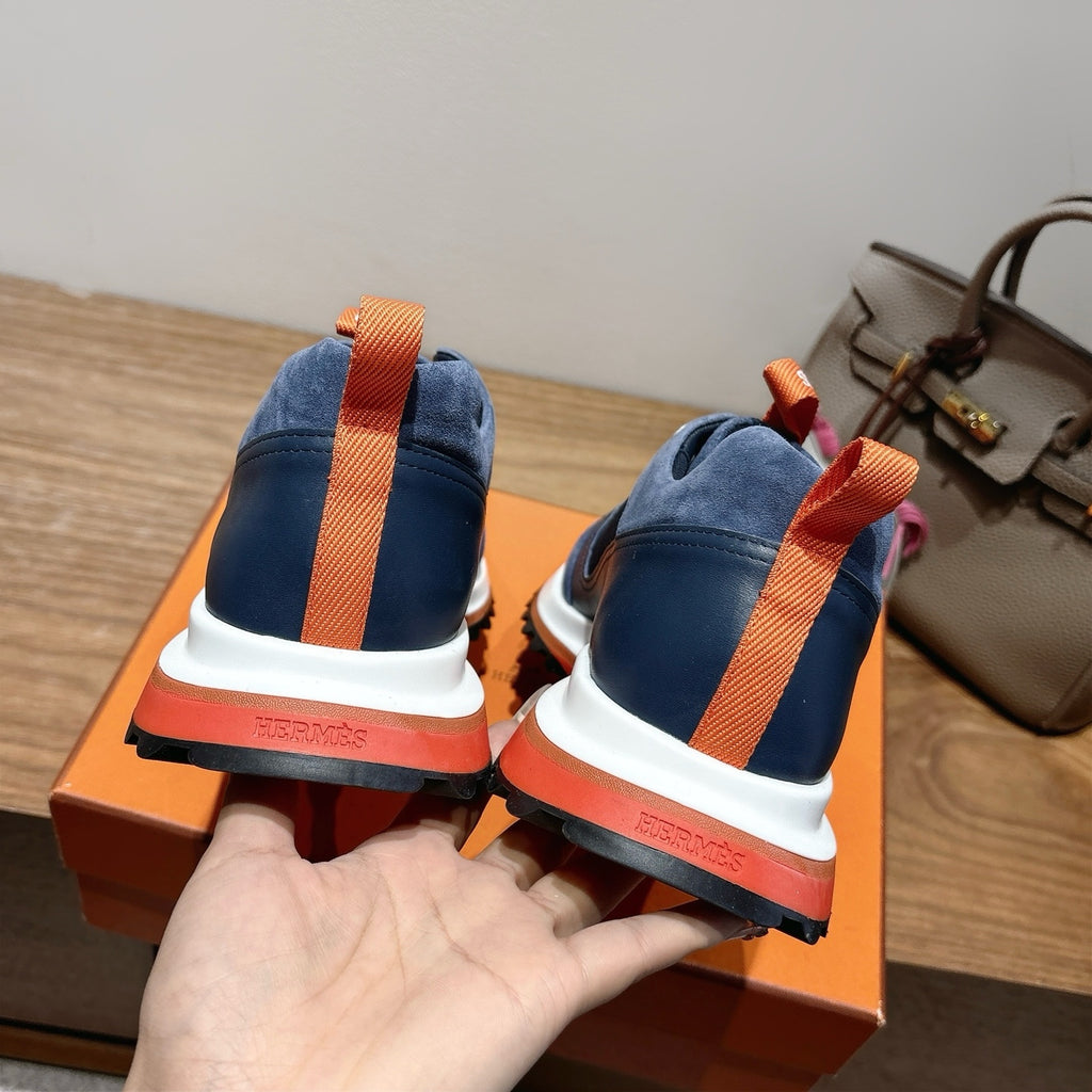 Hermes unisex sneakers heel view, navy blue with orange strap and white/red sole