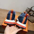 Hermes unisex sneakers heel view, navy blue with orange strap and white/red sole