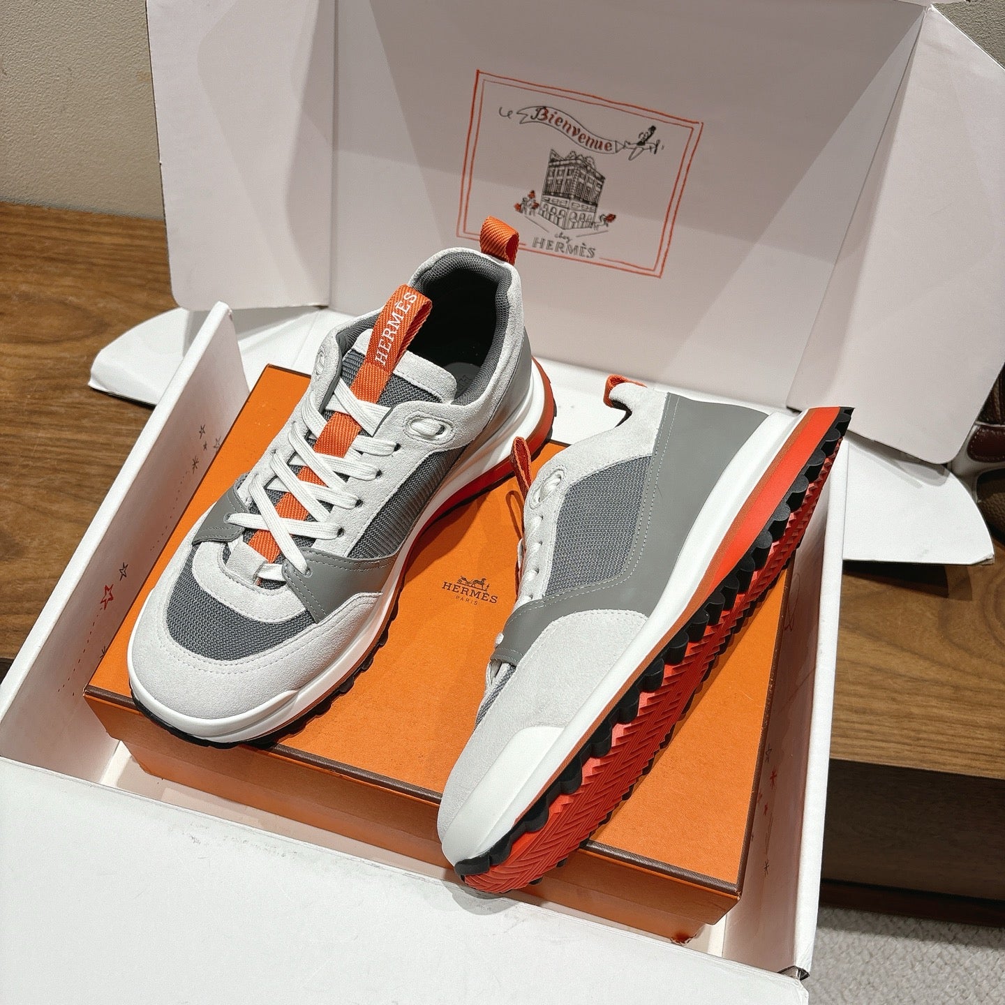 Hermes unisex sneakers in box, white and gray uppers with orange-soled edge trim