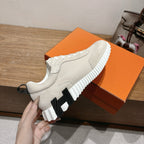 Hermes unisex sneakers held up, light beige upper with chunky striped rubber sole