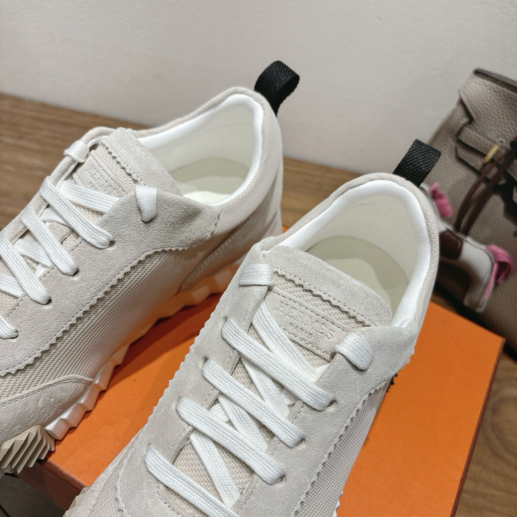 Hermes unisex sneakers close-up: light beige canvas/leather upper with white lace stitching