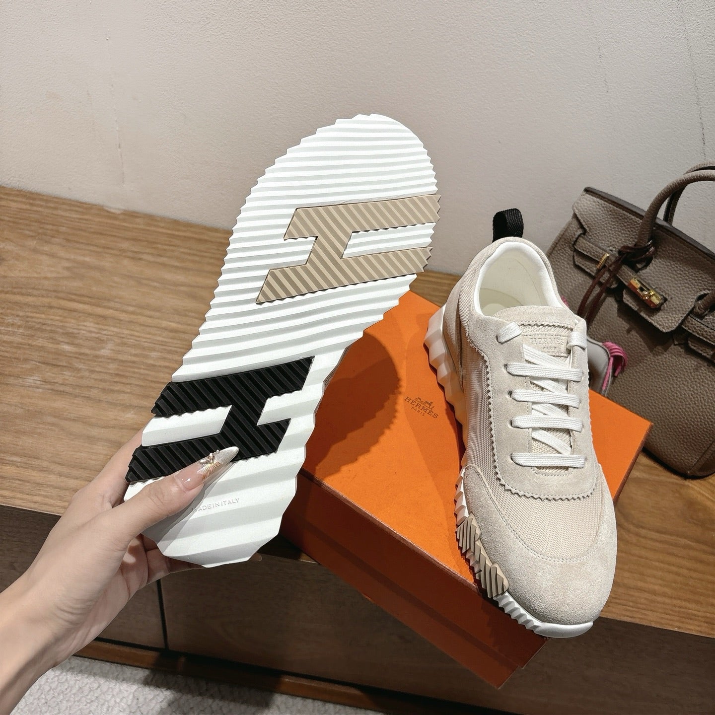 Hermes unisex sneaker sole and side view, light beige with bold tread pattern and logo