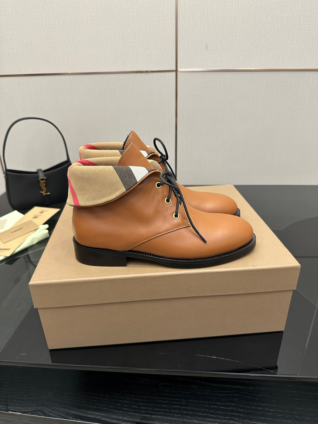 Tan lace-up shoe with black sole and plaid fabric collar